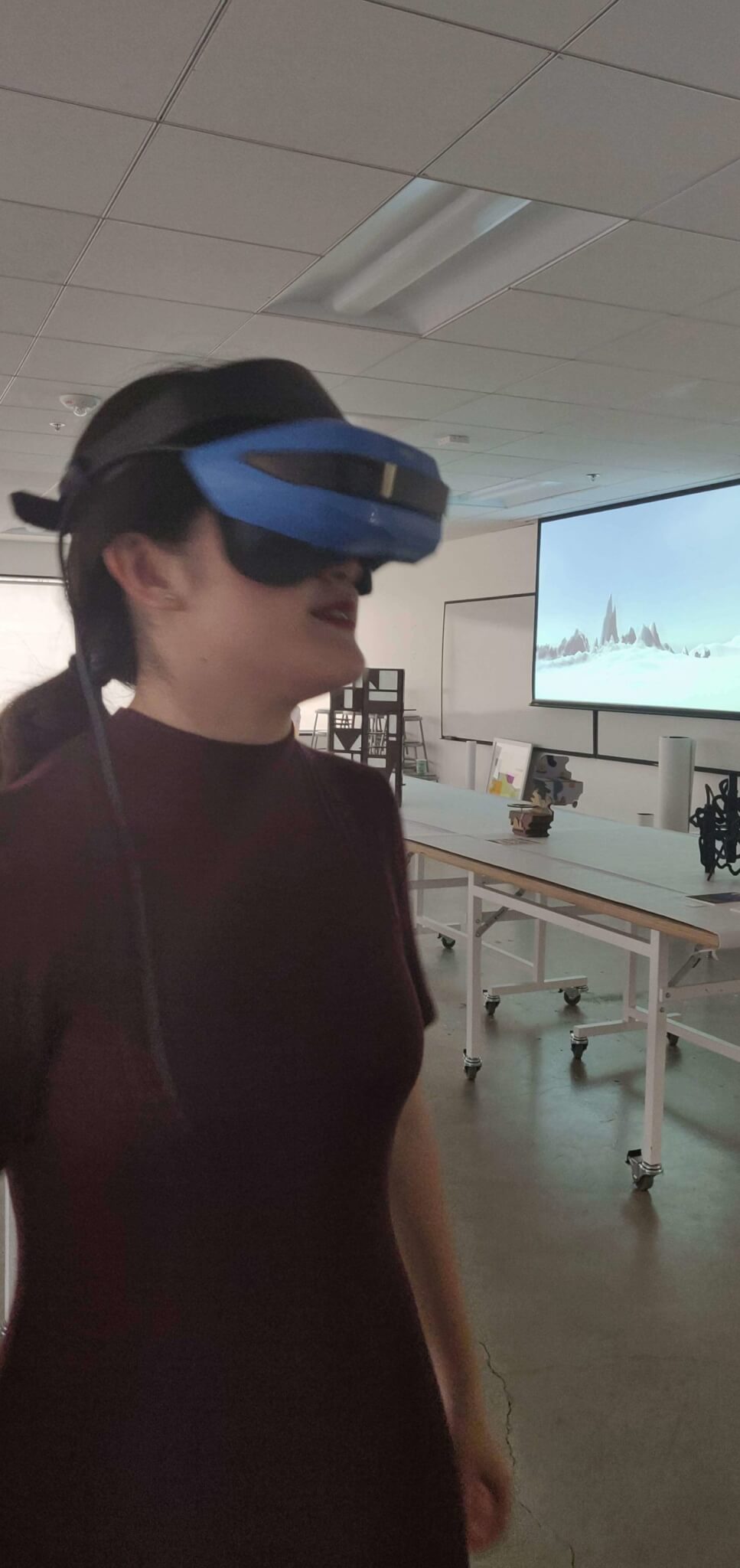 Woman wearing VR headset explores virtual sculpture.